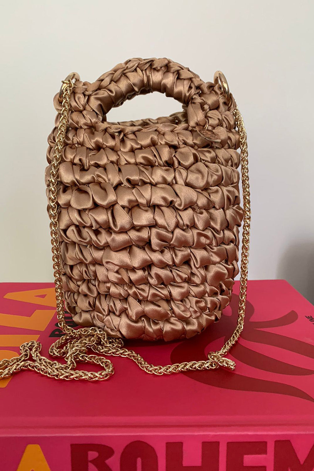 Cartera tejida color dorado.