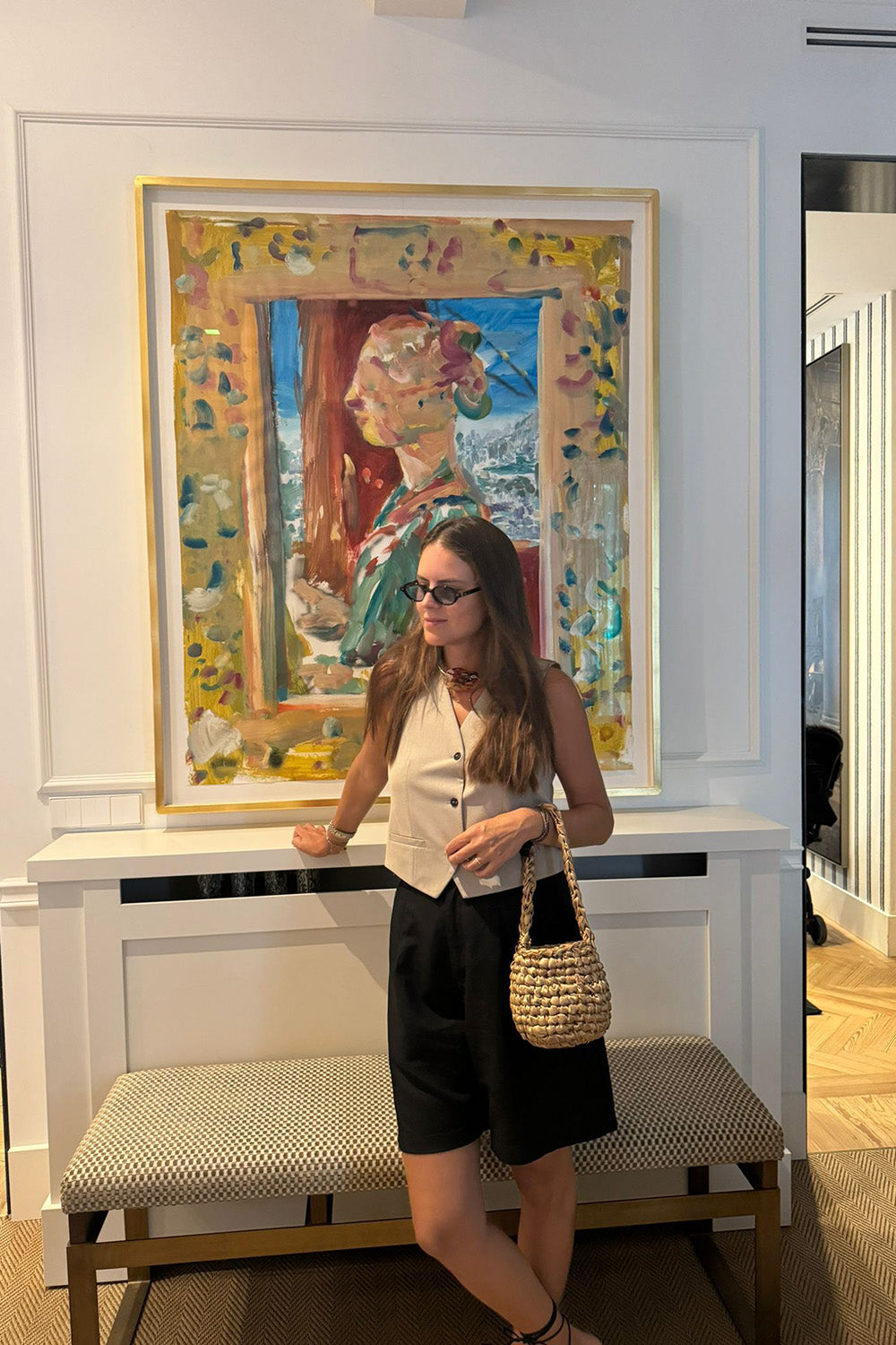 Mujer usando una cartera tejida color dorado.