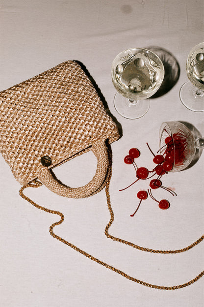 Cartera tejida color beige.