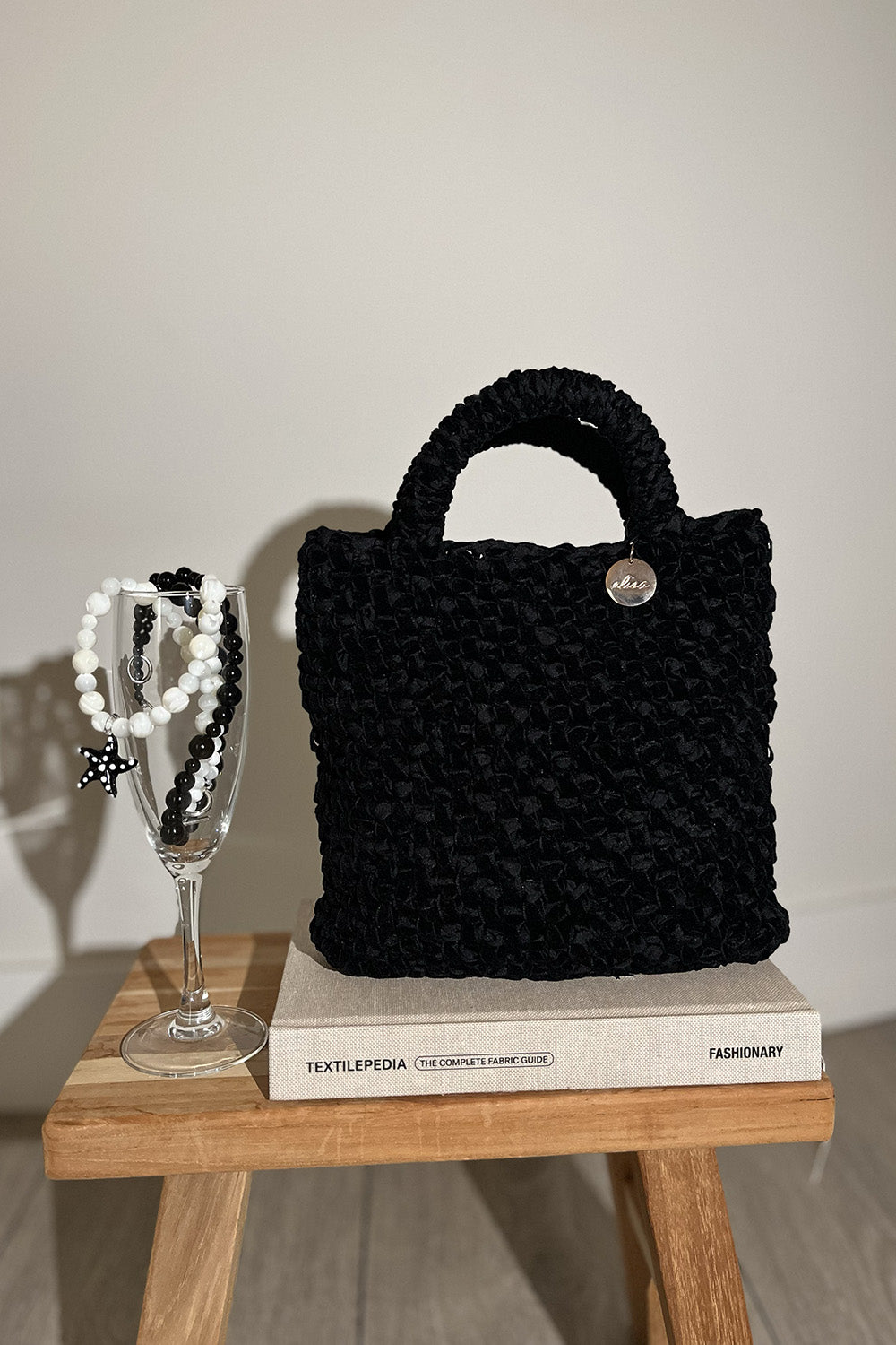 Cartera tejida de velvet color negro.
