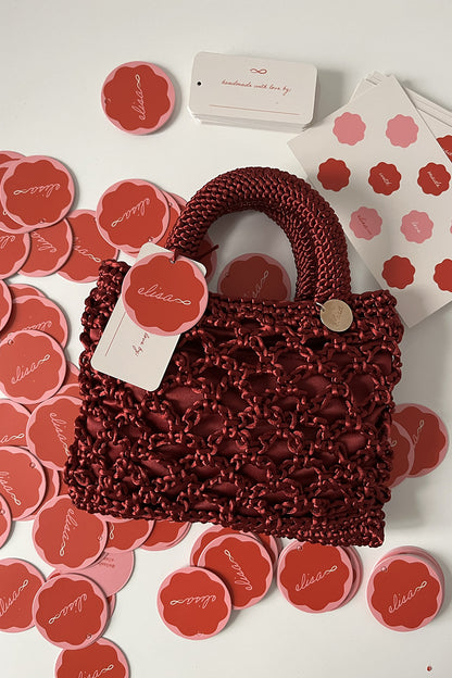 Cartera tejida color guinda.