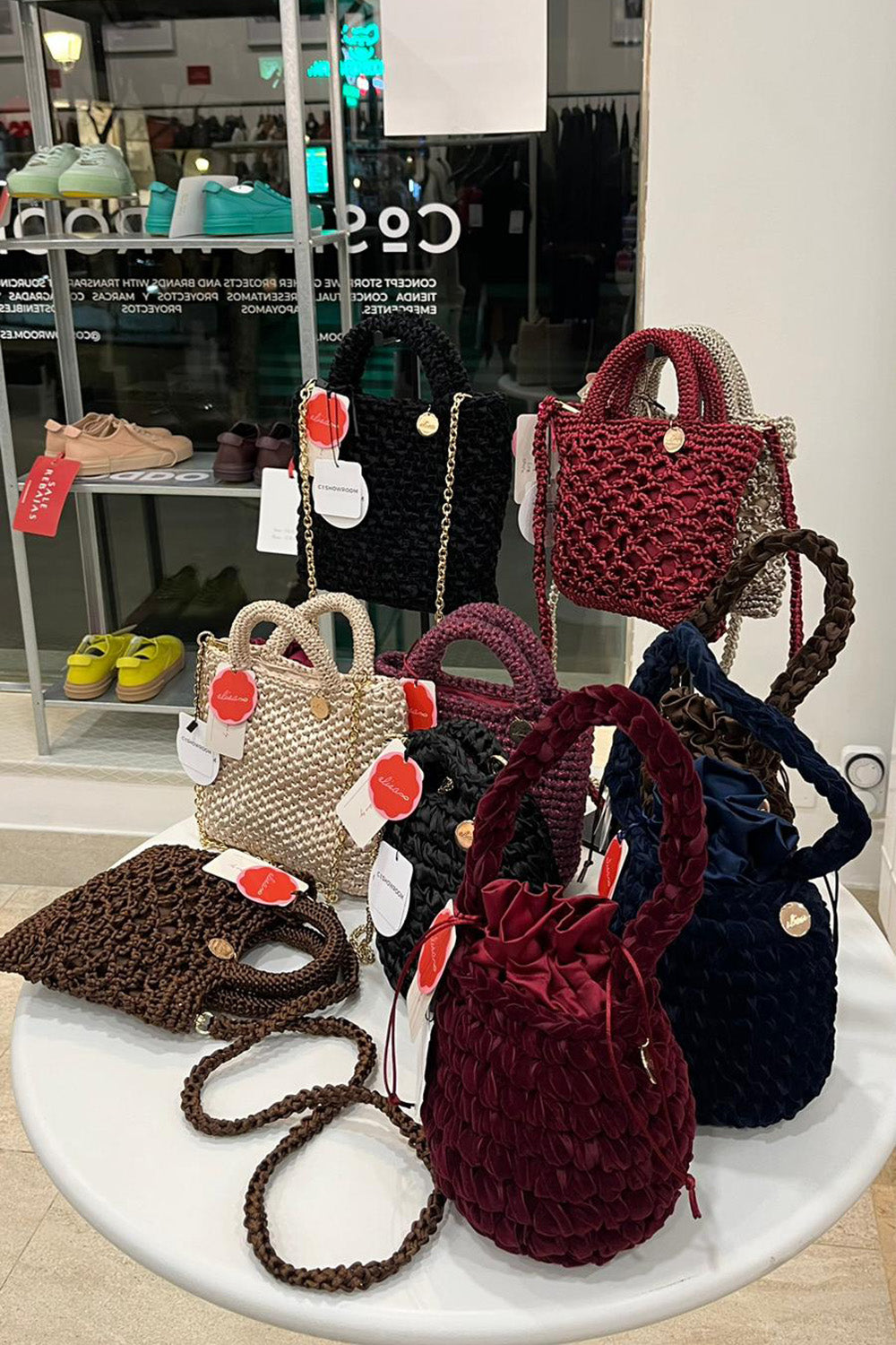 Display de una tienda. Múltiples carteras sobre una mesa blanca.